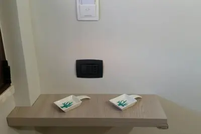 a wooden table with two white dishes on it at Isabella house in Casteldaccia
