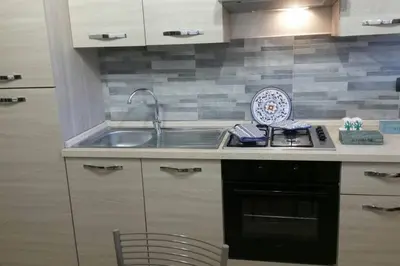 a kitchen counter with a sink and a stove at Isabella house in Casteldaccia