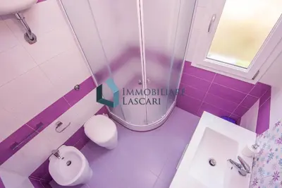 a pink bathroom with a toilet and a sink at Villa Luana, a pochi passi dal mare in Lascari