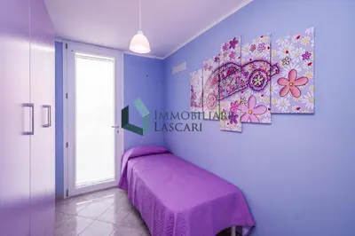 a purple bedroom with a bed and a window at Villa Luana, a pochi passi dal mare in Lascari