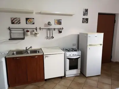 a kitchen with a sink and a stove and refrigerator at La Casetta della Musica in Mondello