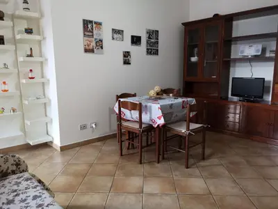 a dining room with a table and chairs and a tv at La Casetta della Musica in Mondello