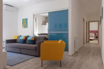 a living room with a couch and a yellow chair at 29/4 Exclusive Suite tra Teatro Massimo e Porto in Palermo