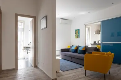 a living room with a couch and a yellow chair at 29/4 Exclusive Suite tra Teatro Massimo e Porto in Palermo