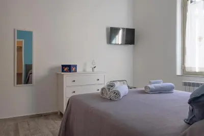a white bedroom with a bed and a dresser at 29/4 Exclusive Suite tra Teatro Massimo e Porto in Palermo