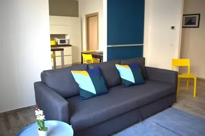 a living room with a gray couch with colorful pillows at 29/4 Exclusive Suite tra Teatro Massimo e Porto in Palermo
