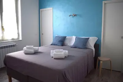 a blue bedroom with a large bed with towels on it at 29/4 Exclusive Suite tra Teatro Massimo e Porto in Palermo