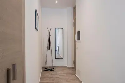 a hallway with white walls and a mirror at 29/4 Exclusive Suite tra Teatro Massimo e Porto in Palermo