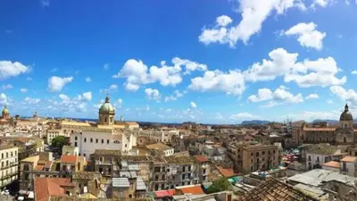 a city with buildings and a blue sky with clouds at Alle Porte del Capo in Palermo