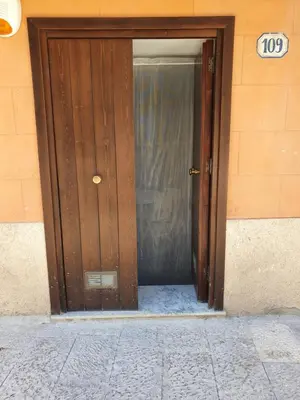 a wooden door to a building with a sign on it at Alle Porte del Capo in Palermo