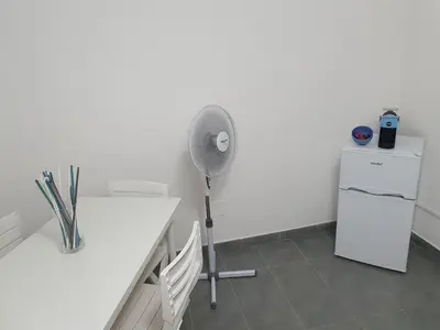 a room with a desk with a fan and a refrigerator at Alle Porte del Capo in Palermo