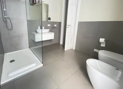 a bathroom with a shower and a toilet and a sink at BARRIQUE Guest House in Palermo