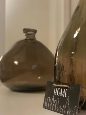 a glass bottle with a home sign next to it at BARRIQUE Guest House in Palermo