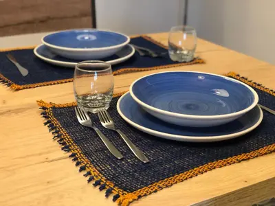 a wooden table with plates and forks and glasses at BARRIQUE Guest House in Palermo