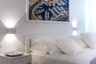 a white bed with white pillows and a picture on the wall at La Home42 Suite in Palermo