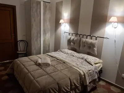 a bedroom with a bed and two lights on the wall at Agorà Sant’anna Apartment in Palermo