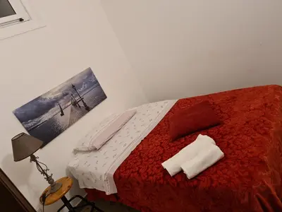 a bedroom with a red bed with a picture on the wall at Agorà Sant’anna Apartment in Palermo