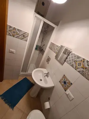 a bathroom with a sink and a shower and a toilet at Agorà Sant’anna Apartment in Palermo