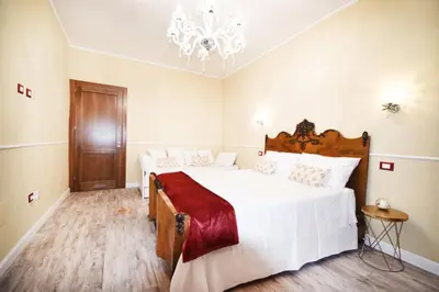 a bedroom with a large bed and a chandelier at Luxury Apartment Via Genova in Palermo