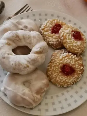 four donuts on a white plate on a table at Luxury Apartment Via Genova in Palermo