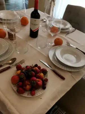 a table with a plate of fruit and a bottle of wine at Luxury Apartment Via Genova in Palermo