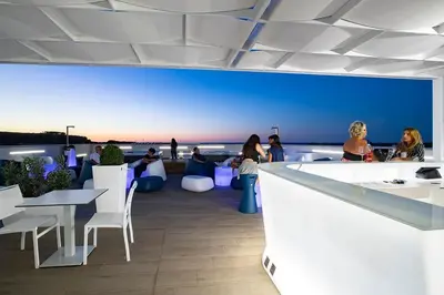 a restaurant with a view of the ocean with people sitting at tables at Sundeck Hotel in San Vito lo Capo