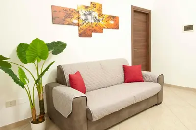 a couch with two red pillows in a living room at Casa vacanza da Marisa in Partinico