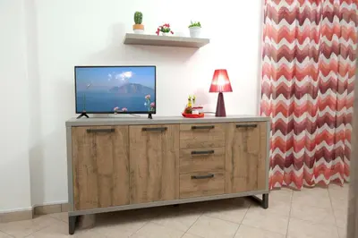 a tv sitting on top of a wooden cabinet at Casa vacanza da Marisa in Partinico