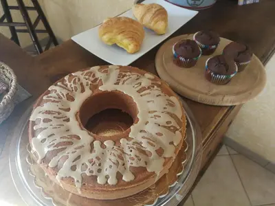 a bundt cake and cupcakes on plates on a table at Dimora Di Campagna in Portella di Mare