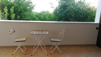 two chairs and a table in front of a window at Dimora Di Campagna in Portella di Mare