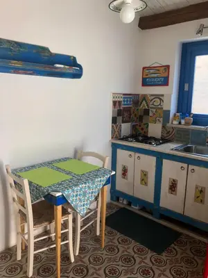 a kitchen with a table and a stove and a sink at Casa Colore Attic in Castellammare del Golfo