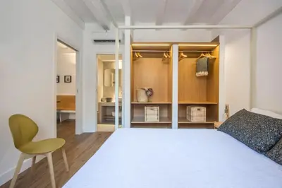 a bedroom with a white bed and a yellow chair at Le Niche Holiday Homes by Wonderful Italy in Palermo