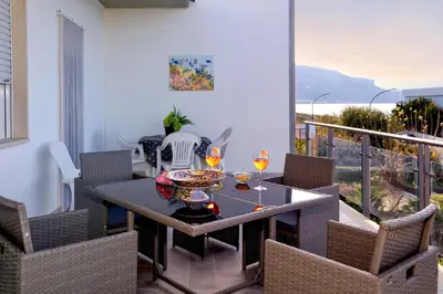 a dining room with a table and chairs on a balcony at Terrazza sul Golfo in Alcamo