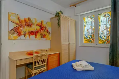 a bedroom with a desk and a table with a blue bed at Terrazza sul Golfo in Alcamo