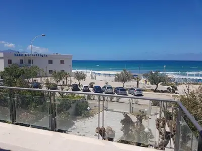 a balcony with a view of a beach and cars at Terrazza sul Golfo in Alcamo