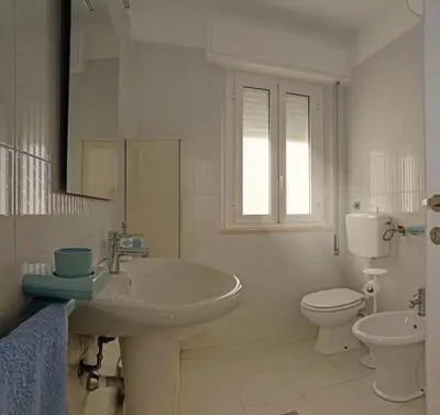a white bathroom with a sink and a toilet at Terrazza sul Golfo in Alcamo