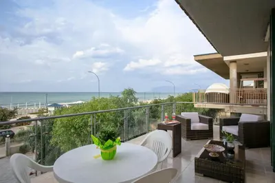 a balcony with a table and chairs and the ocean at Terrazza sul Golfo in Alcamo