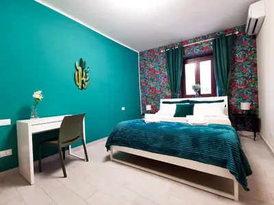 a blue bedroom with a bed and a desk at Casa Ciuri in Palermo