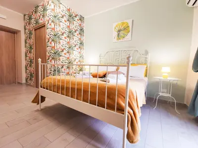 a bedroom with a bed with a orange blanket at Casa Ciuri in Palermo