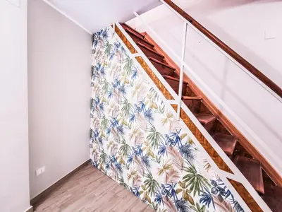 a staircase with a mural of palm trees on the wall at Casa Ciuri in Palermo