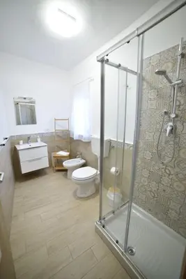 a bathroom with a shower and a toilet and a sink at Casa Ciuri in Palermo