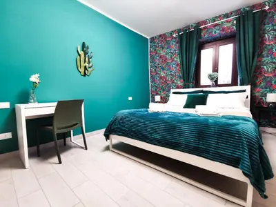 a blue bedroom with a bed and a desk at Casa Ciuri in Palermo