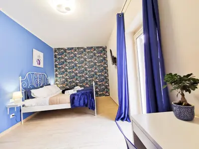 a bedroom with blue walls and a bed with blue curtains at Casa Ciuri in Palermo