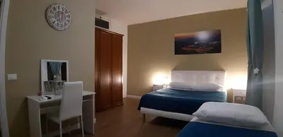 a bedroom with a bed and a table and a clock at GUEST HOUSE PIANA DEGLI ALBANESI in Piana degli Albanesi