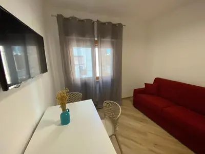 a living room with a table and a red couch at Belmonte Apartments in Palermo