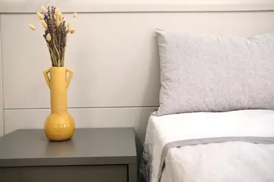 a yellow vase sitting on a table next to a bed at Belmonte Apartments in Palermo