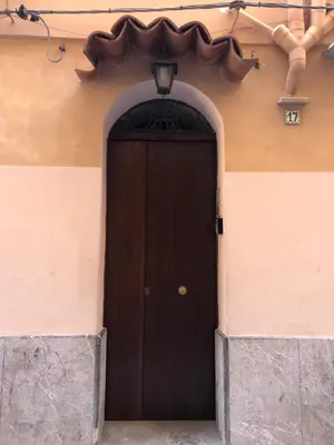 a brown door in the side of a building at Tanto di Cappello Home in Palermo