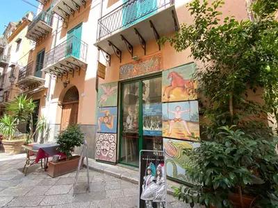 a store with paintings on the side of a building at Tanto di Cappello Home in Palermo