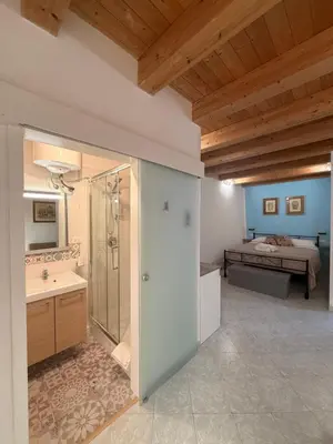a large bathroom with a shower and a bed at Tanto di Cappello Home in Palermo