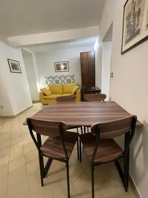 a living room with a table and chairs and a yellow couch at Normanni Central House in Palermo